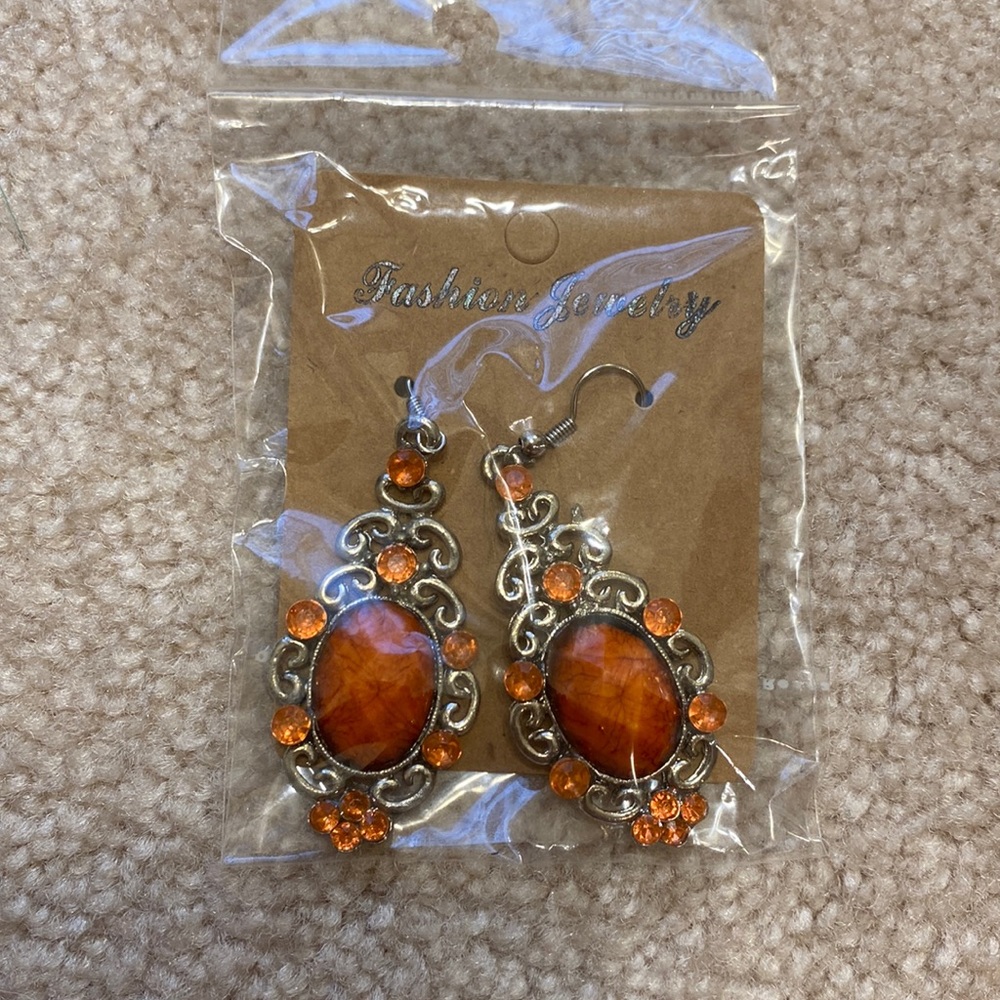 Orange dangle earrings with rhinestones. New in packaging!